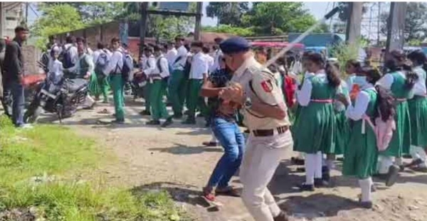 प्रदर्शनकारी छात्रों को लाठी से डाराते पुलिस 