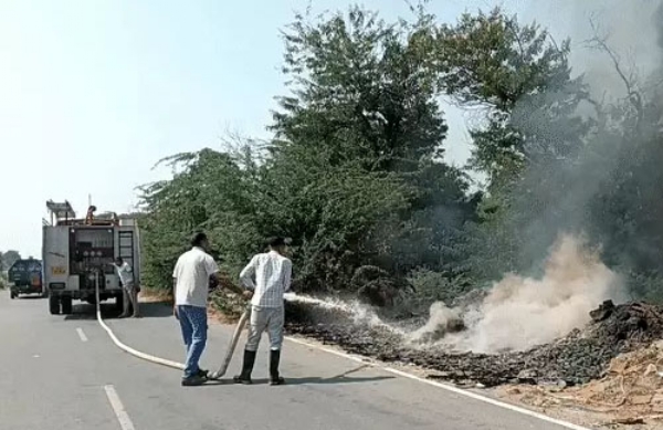 आग बुझाते हुए दमकल कर्मचारी।