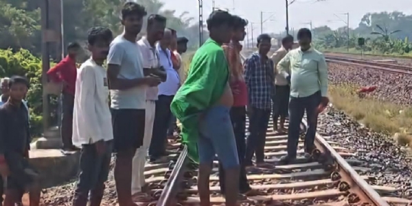 ट्रेन लाइन पर खड़े स्थानीय लोग शव को लेकर जाने की तैयारी में