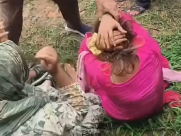 पिटाई के दौरान जमीन पर बैठी महिलाएं। पिटाई के दौरान जमीन पर बैठी महिलाएं।